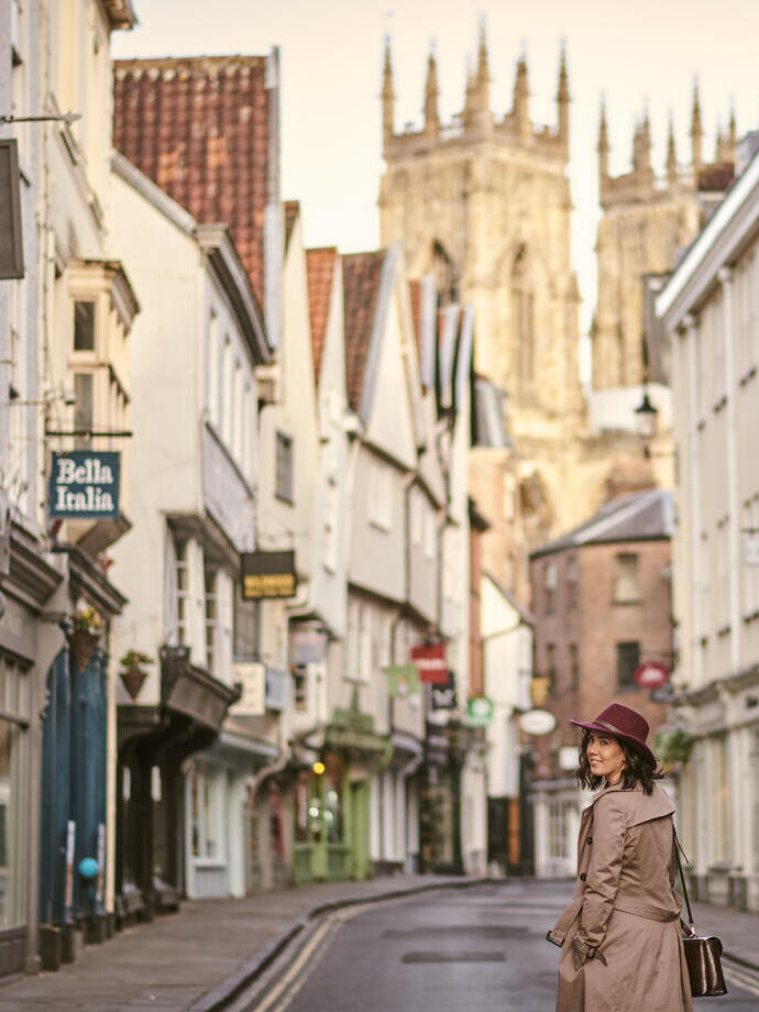 Frau, die durch eine enge historische Straße in einer Stadt geht