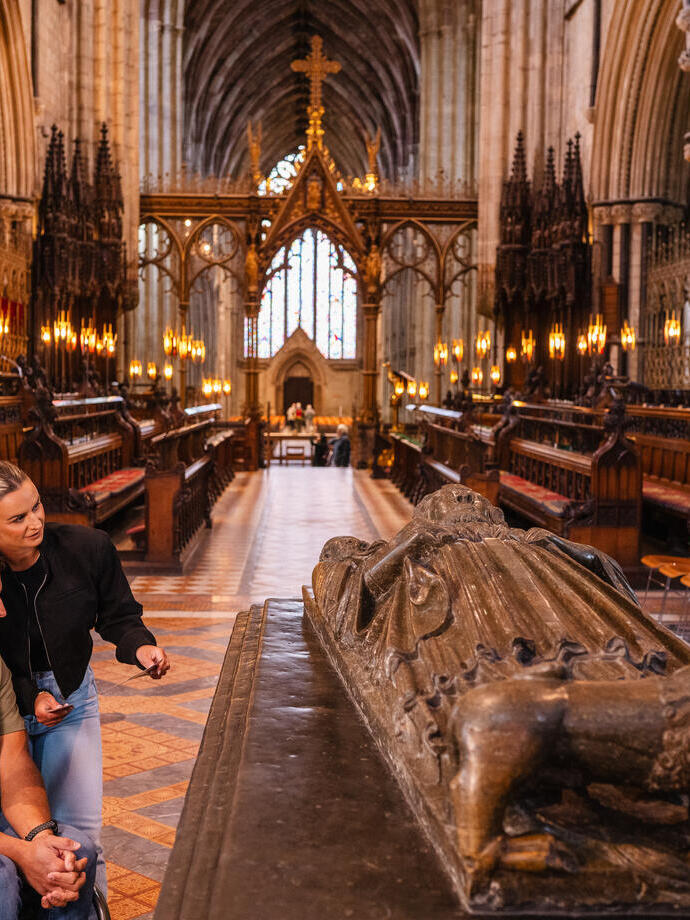 Un hombre y una mujer contemplan el lugar de descanso del rey Juan, enterrado en la catedral de Worcester
