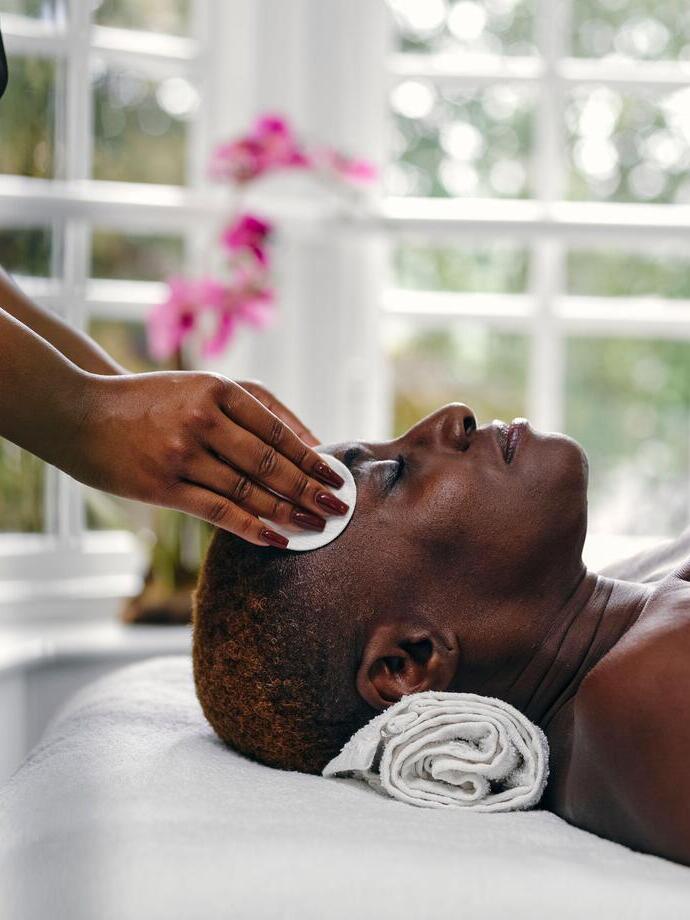 A woman getting a face massage at a hotel spa.
