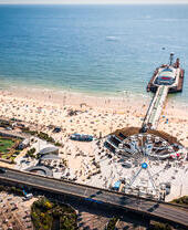 Aerial view of Bournemouth Pier looking out to sea with beach full of people
