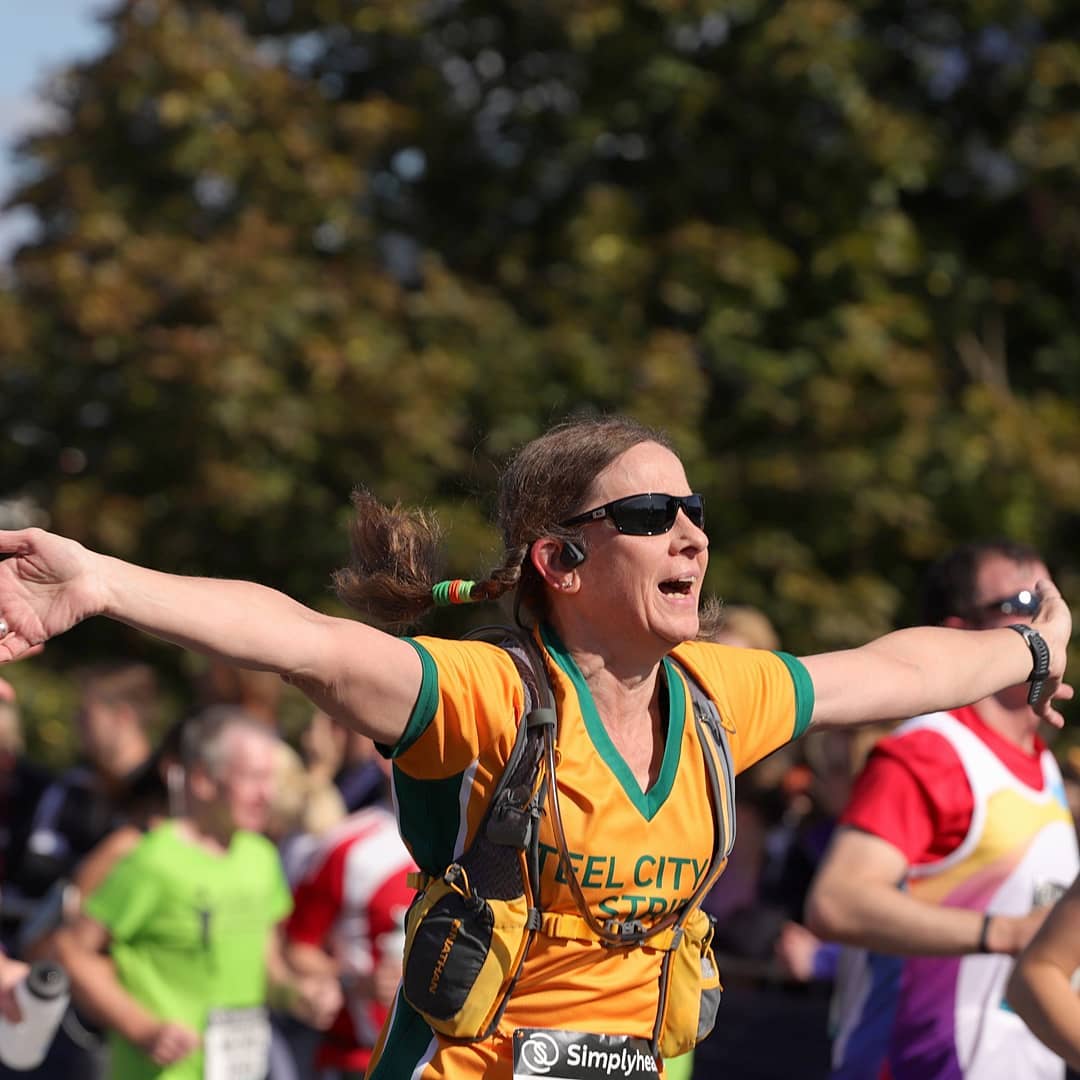 A woman celebrating while crossing the finish line on a run in Newcastle