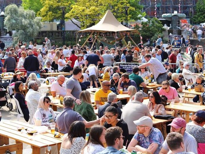 Une foule de personnes mangeant et buvant à l'extérieur dans le cadre du Sheffield Food Festival