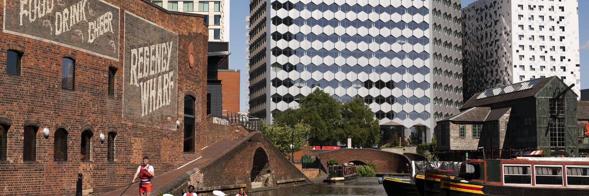 Un groupe de personnes faisant du paddleboard devant le Regency Wharf