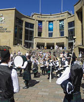 Piping band with drums play for the crowds outside The Glasgow Royal Concert Hall.