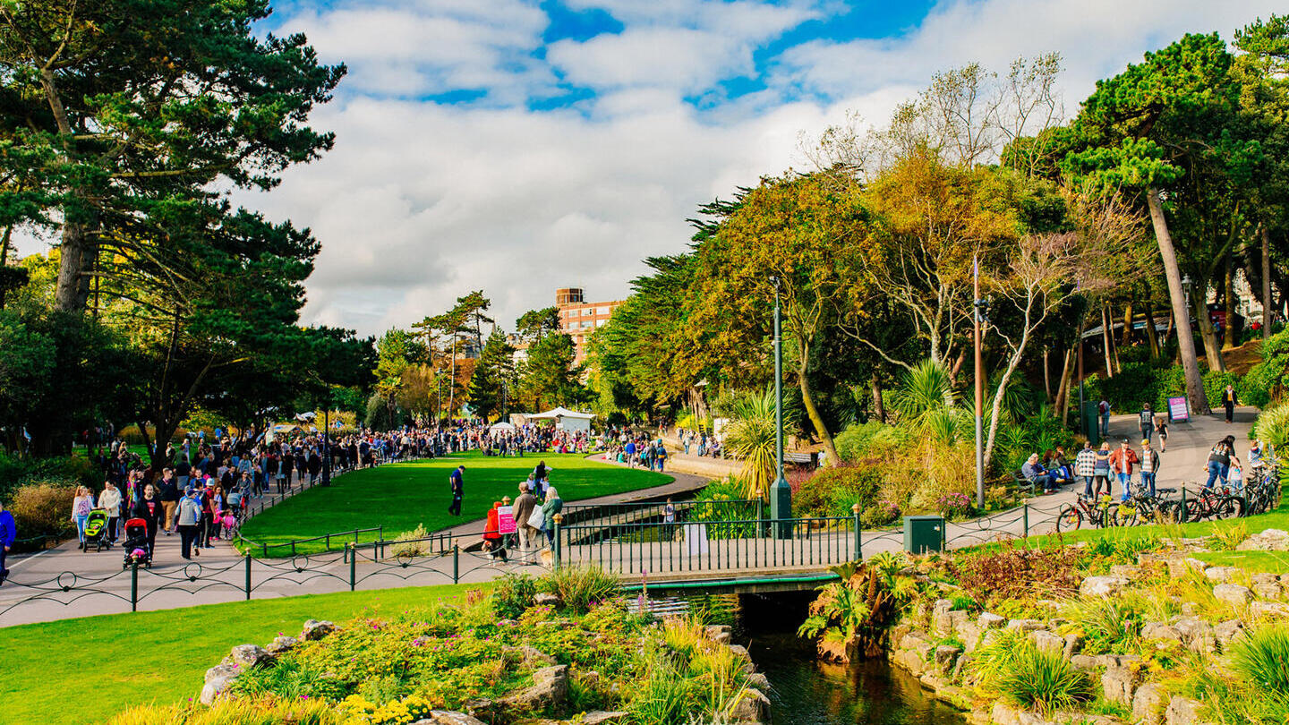 Personas paseando por un parque en un día soleado.