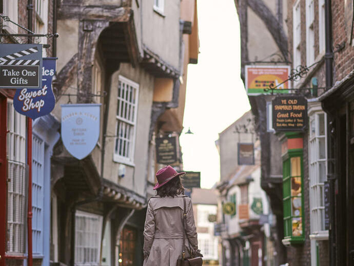 Woman walking through a narrow historic street in a city