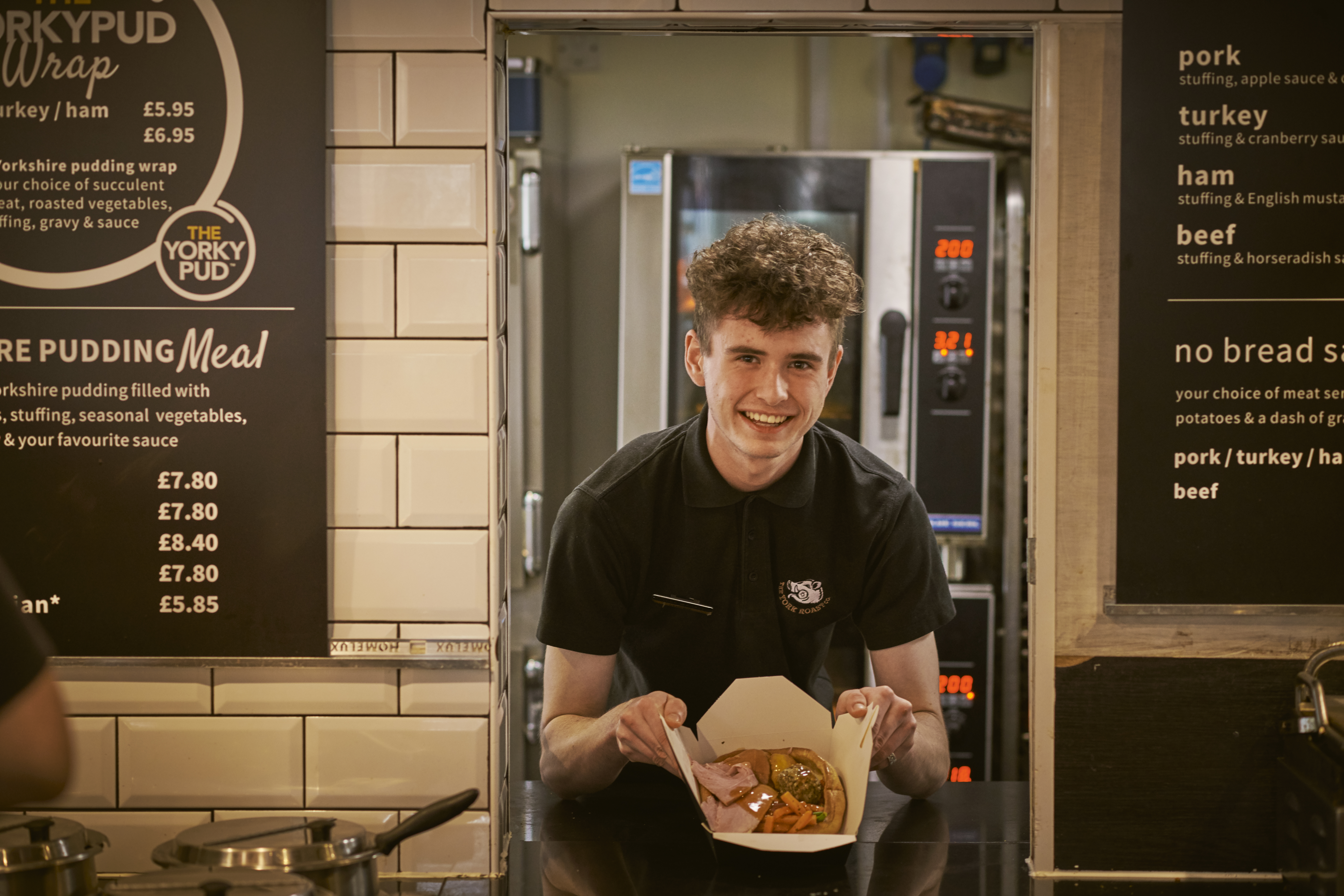 Un hombre sosteniendo comida preparada en la cocina de un restaurante