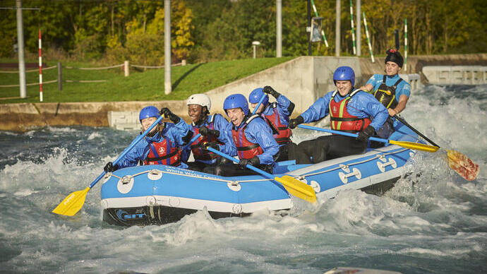Groupe de personnes dans un rafting avec des pagaies sur une rivière avec des rapides