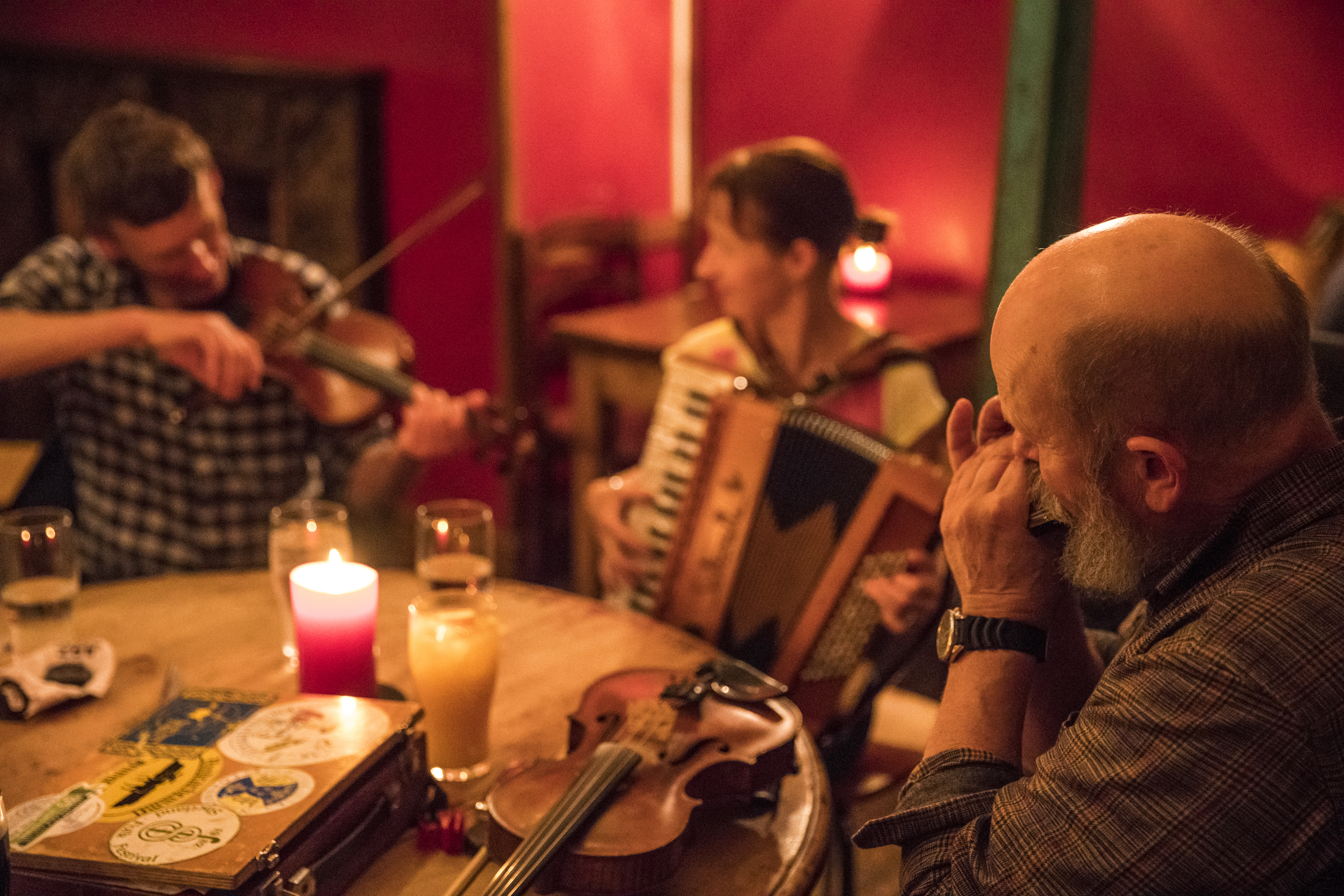 Three musicians playing music in a pub.