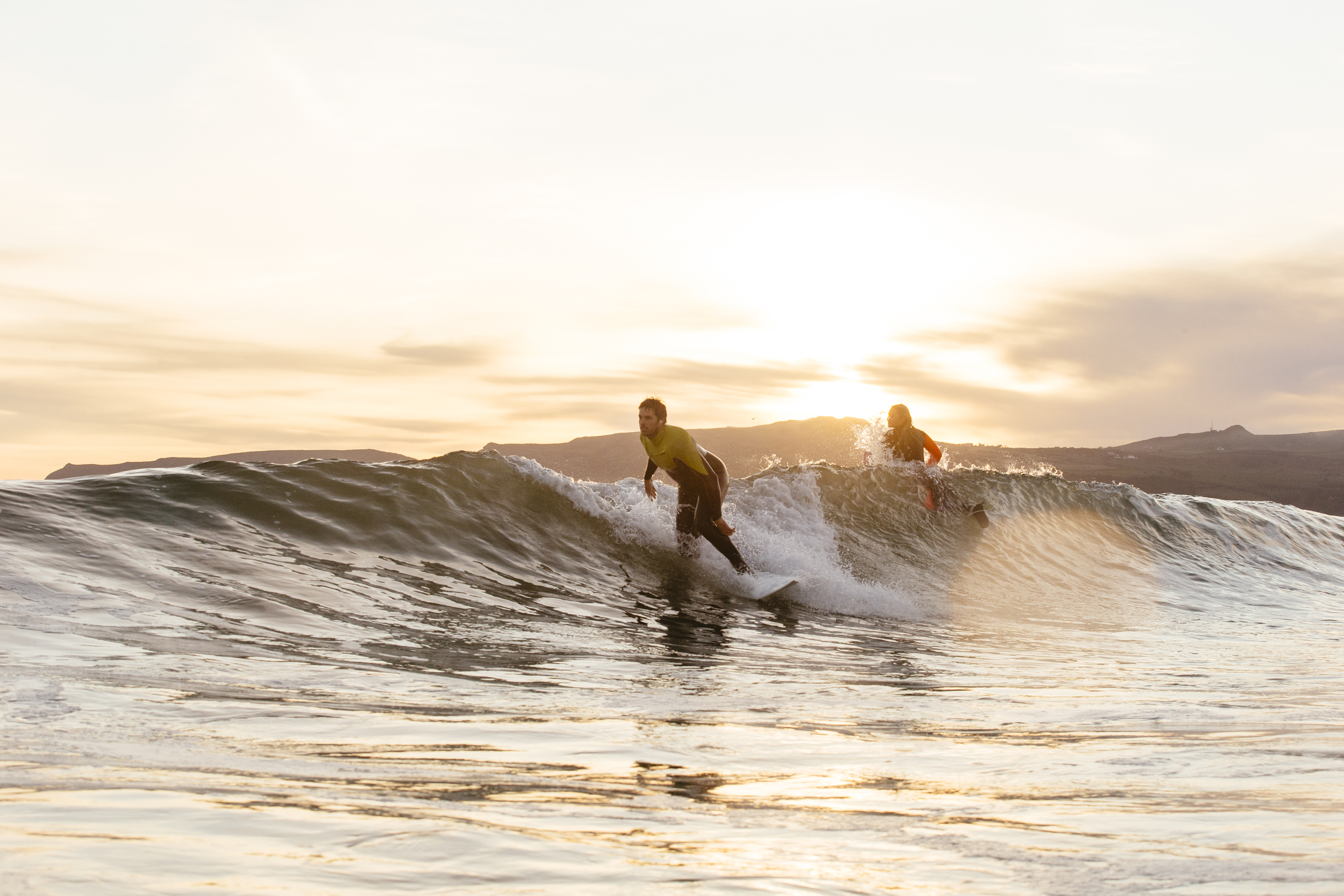 Man and woman, surfing in the sea
