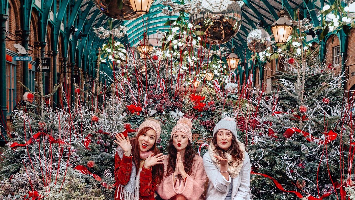Chicas sentadas junto a árboles de Navidad en Covent Garden