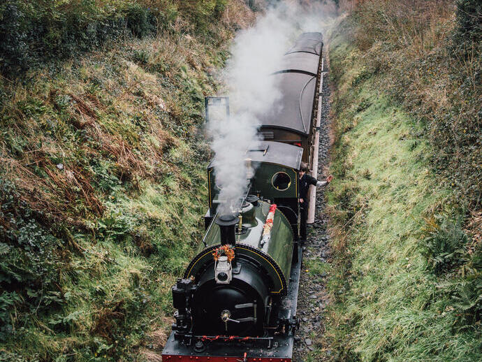 A refurbished heritage steam railway passing through countryside.