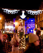 Ein Straßenkünstler unter Weihnachtsbeleuchtung entlang der Hauptstraße in Bath