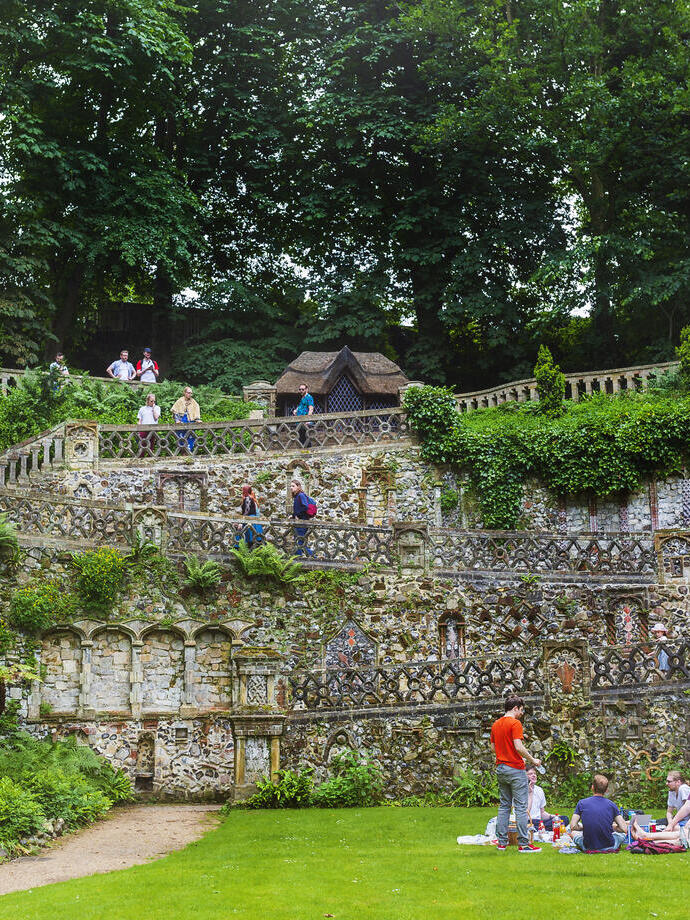 A group of people sitting on a lawn at Plantation Garden Norwich