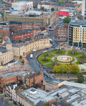 Aerial view of an expansive cityscape with a park and high-rise buildings