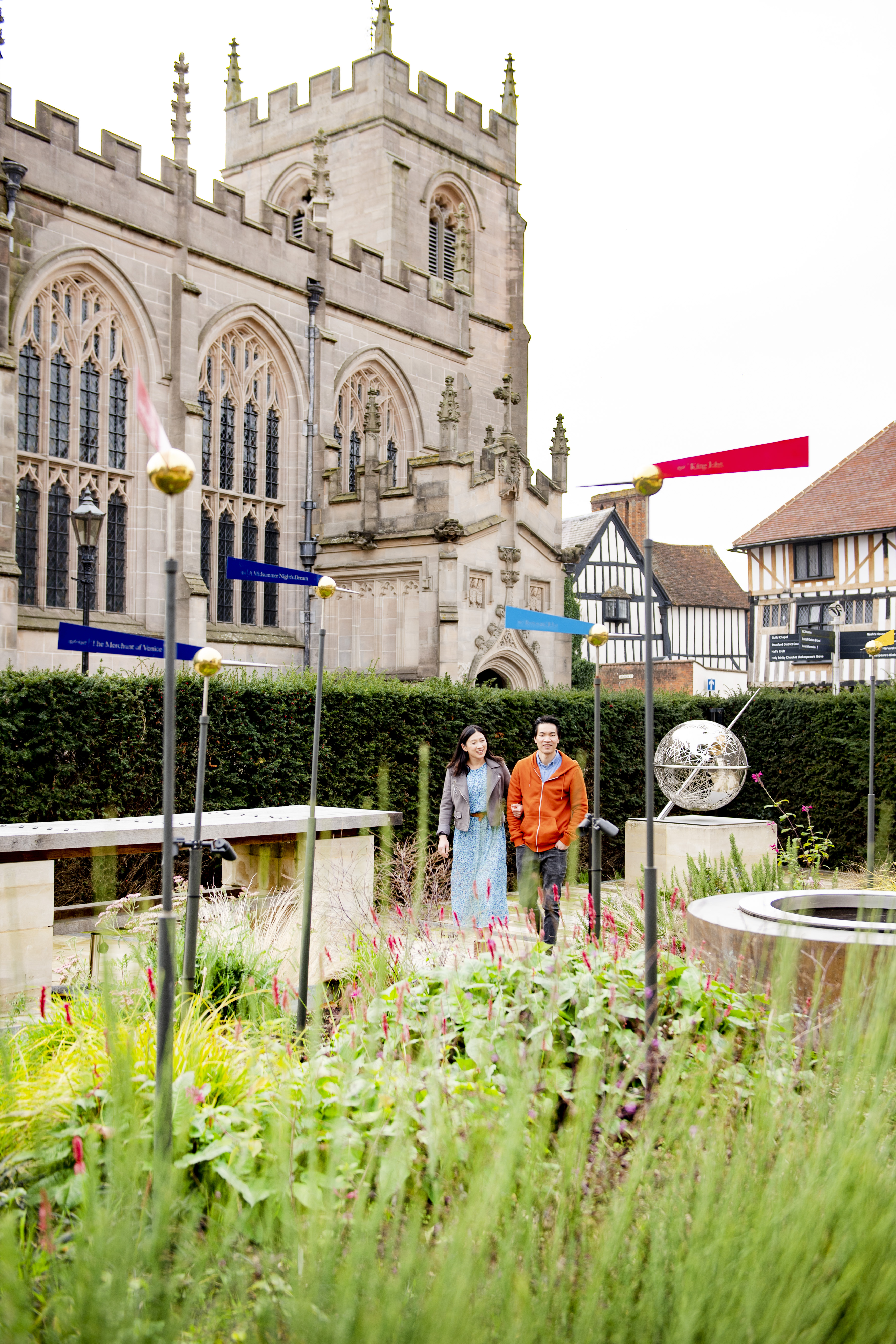 Uomo e donna che camminano in un giardino vicino a una chiesa