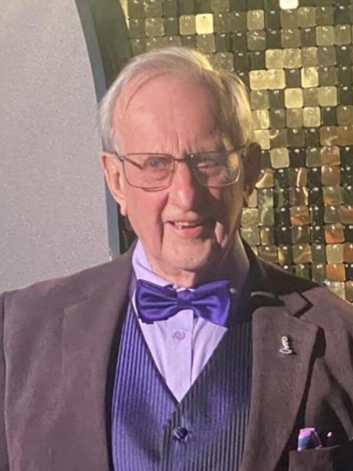 A man wearing a blue bow tie and waistcoat. 