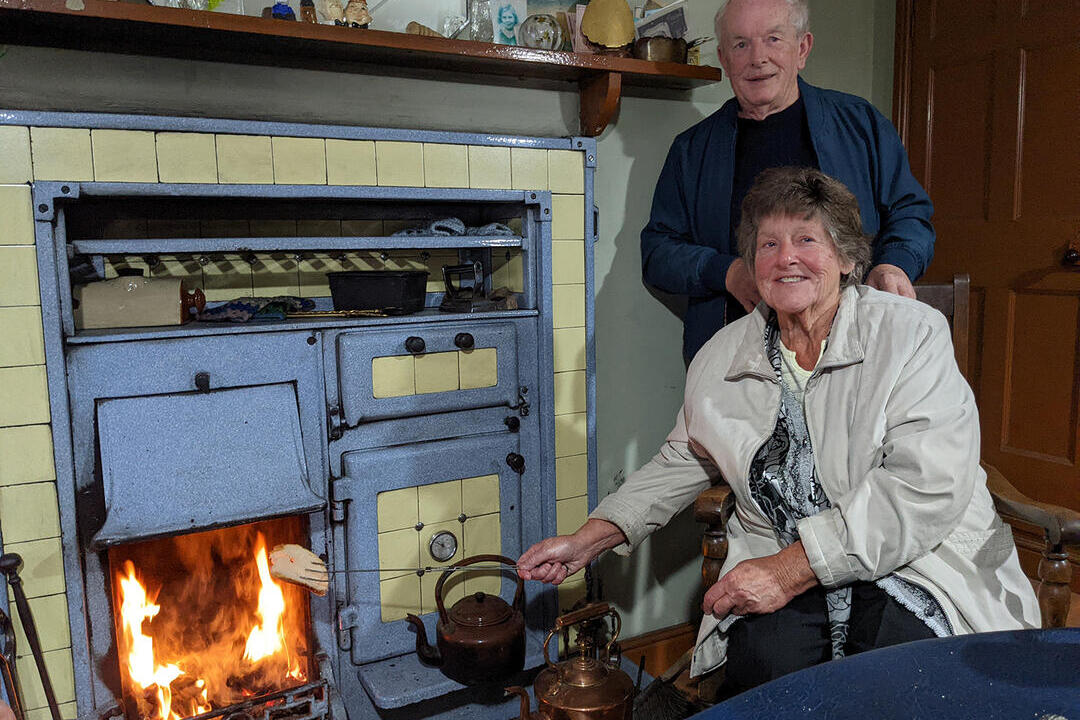 Elderly couple by a fireplace in an historic living museum