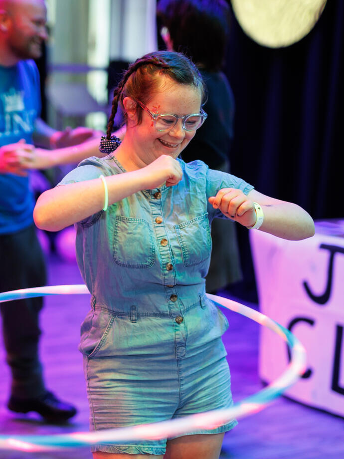  A lady dancing with a hula hoop at a centre for the arts.
