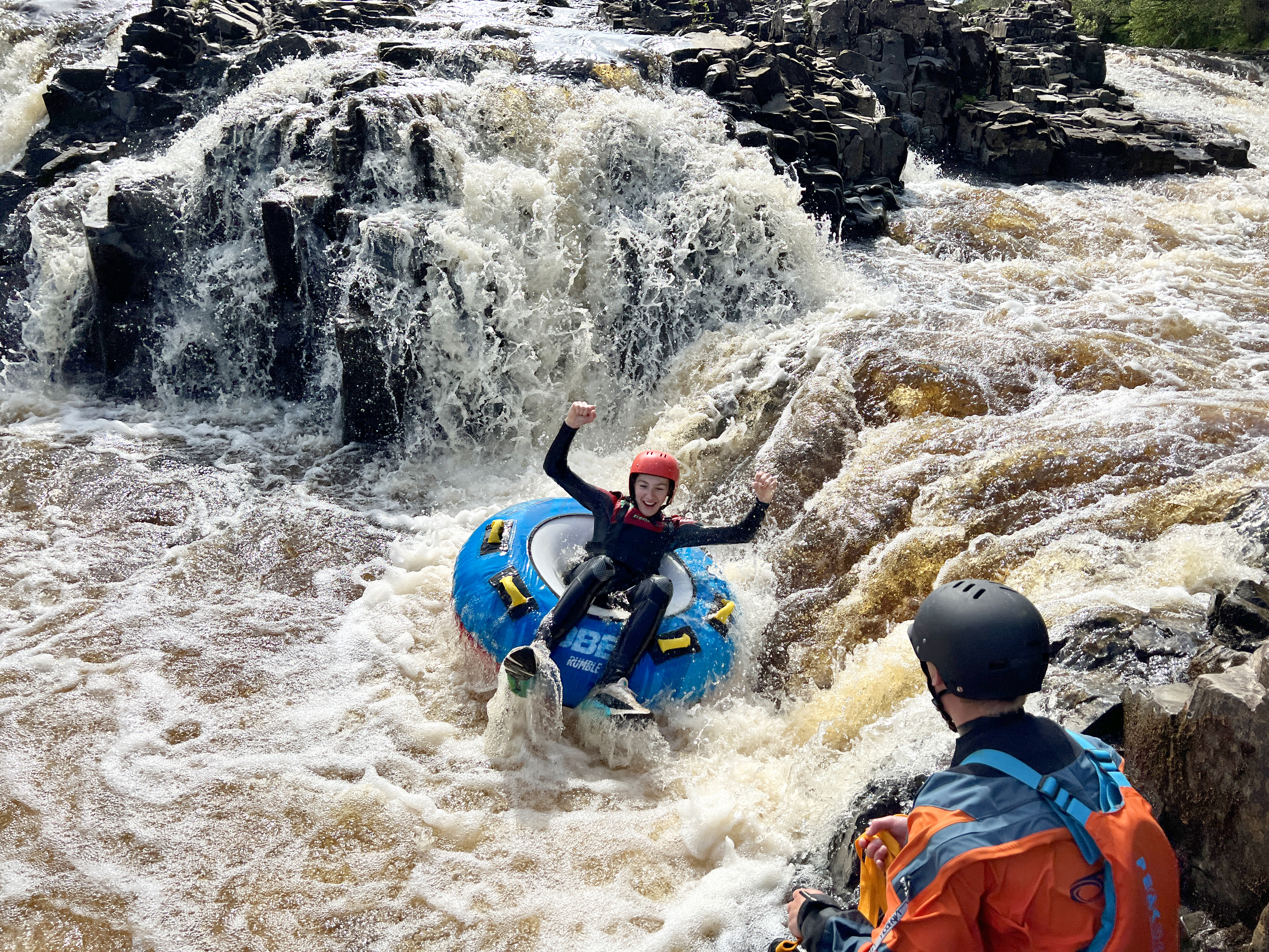 Eine Frau beim Rafting auf Stromschnellen im Endless Adventure North East in Newcastle