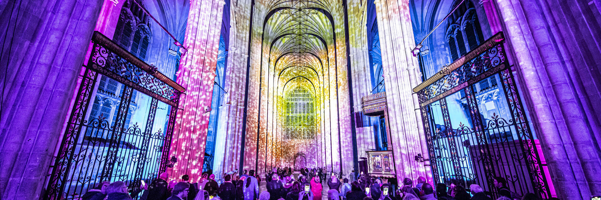 Group of people looking and photographing light show in a cathedral