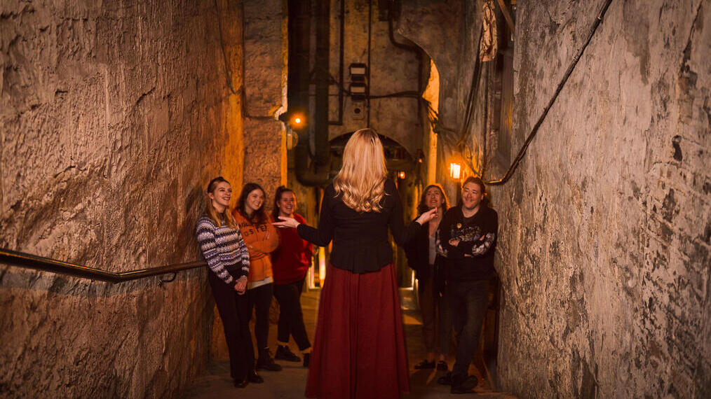 Ein Reiseleiter, der eine Führung durch das Real Mary King's Close in Edinburgh, Schottland, leitet