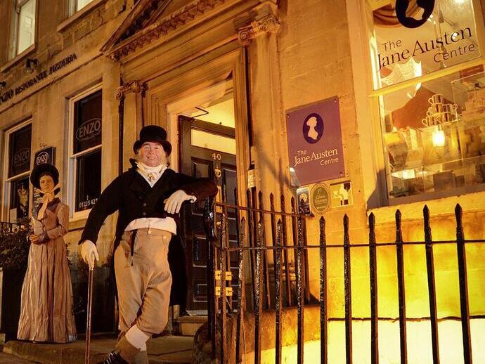 Zwei Personen in historischen Kostümen vor einem viktorianischen Museum.