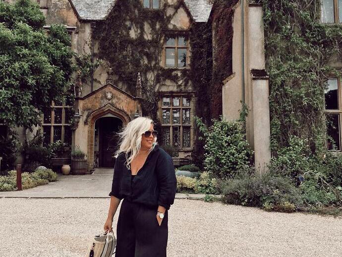 A woman stood outside The Pig Hotel in Combe, Devon