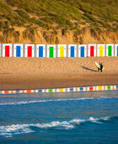 Idyllic scene on surfers beach with beautiful beach huts reflecting in the water