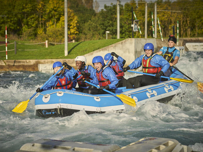 Groupe de personnes dans un rafting avec des pagaies sur une rivière avec des rapides