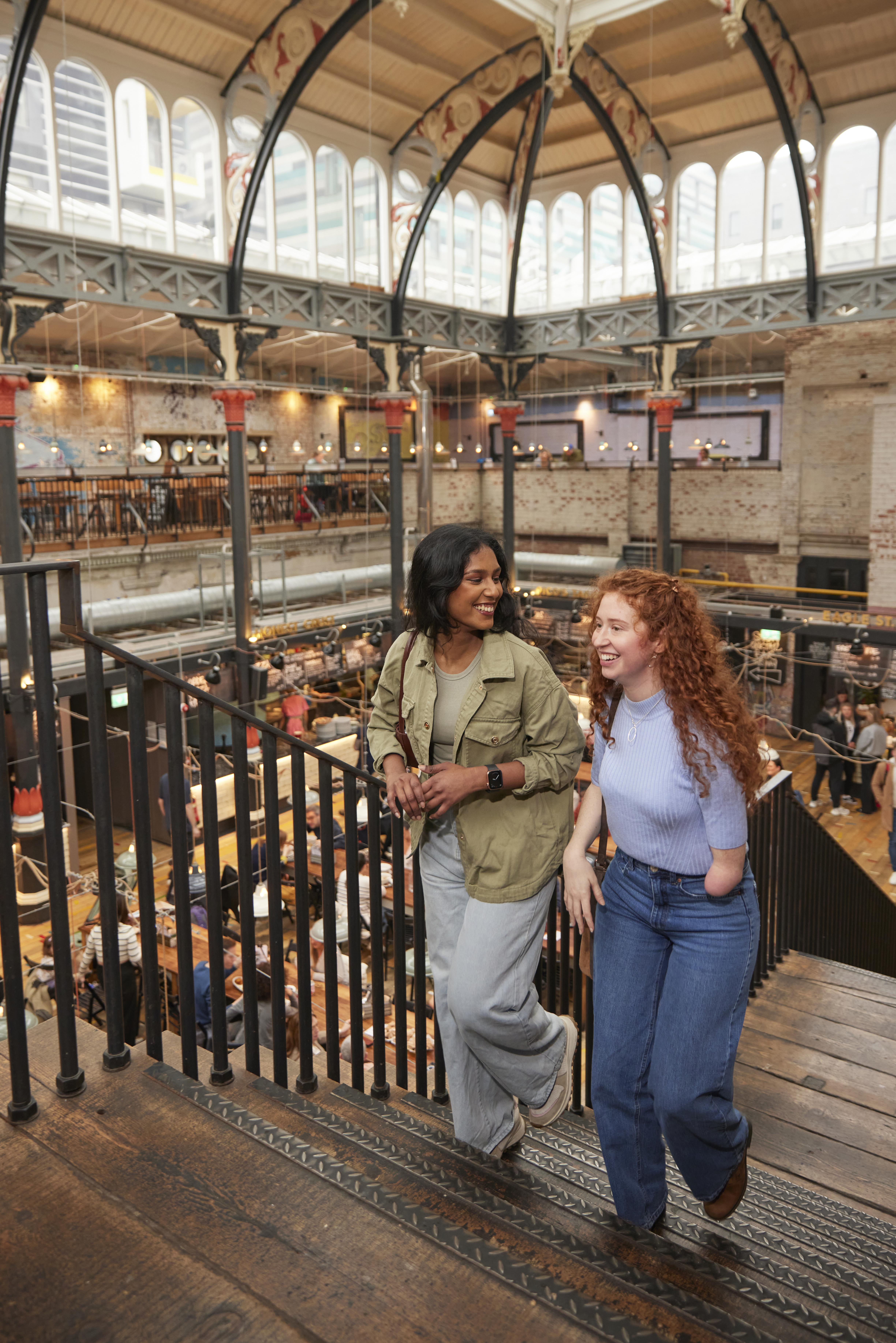 Two women exploring a large open plan food hall.