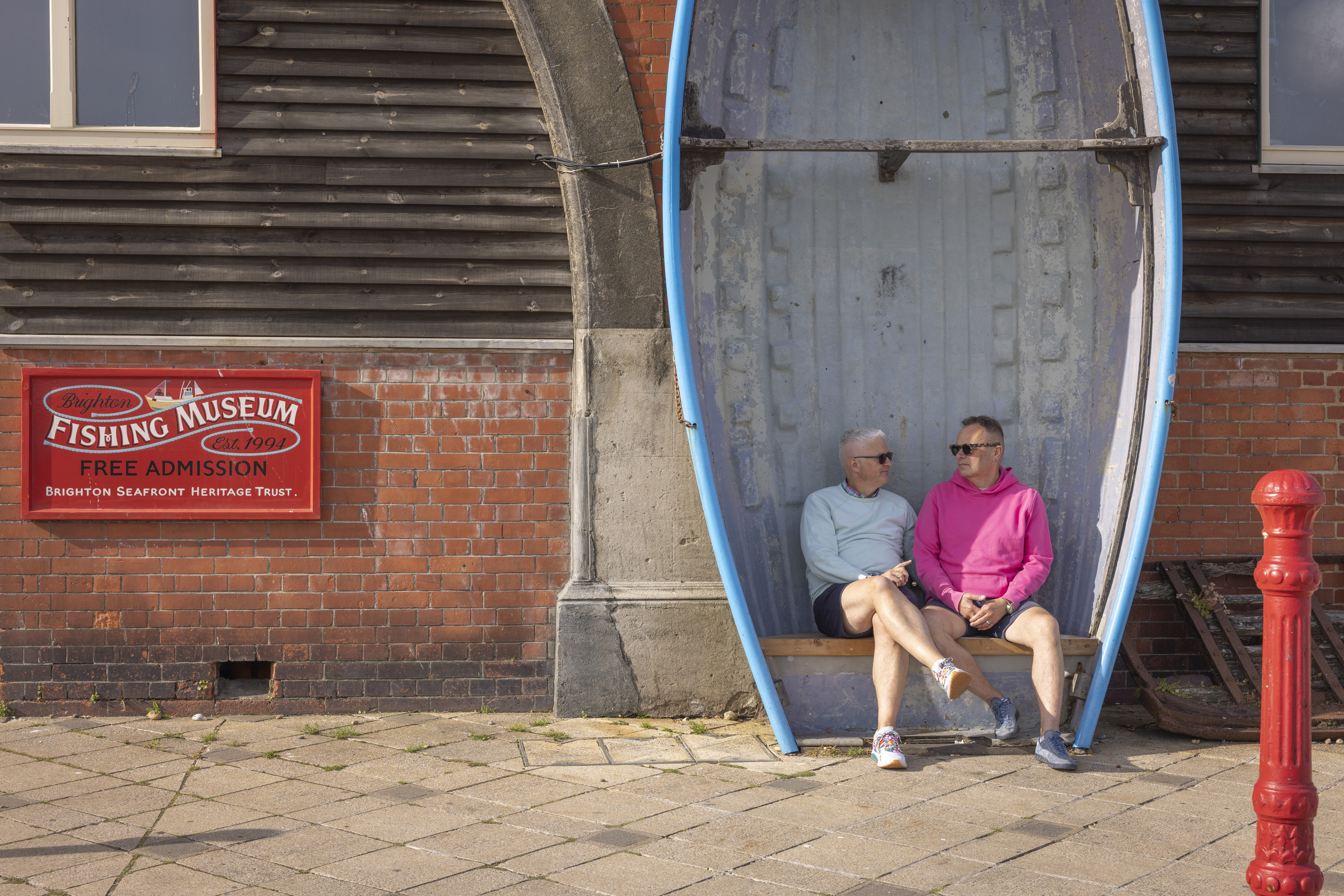 Zwei Männer sitzen auf einer Bank, die aus einem Ruderboot gefertigt wurde