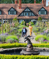 A woman and a man in a wheelchair smiling together in summer gardens