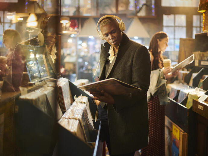 Homme dans un magasin de vinyles vintage tenant un disque