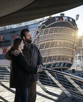 Two people looking over the bow of a ship
