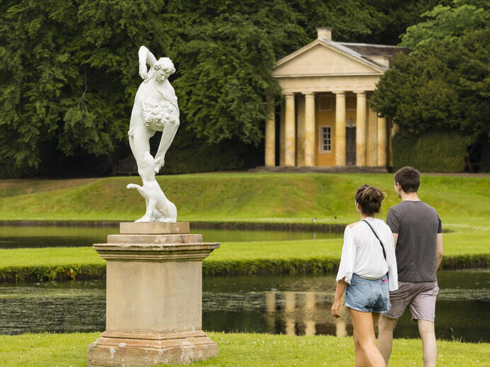 زوجان شابان يتجولان في أراضي Fountains Abbey و Studley Royal Water Garden، شمال يوركشاير