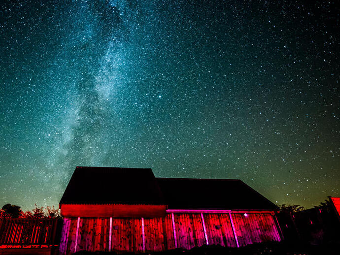 A dark sky observatory lit up at night under the sky.