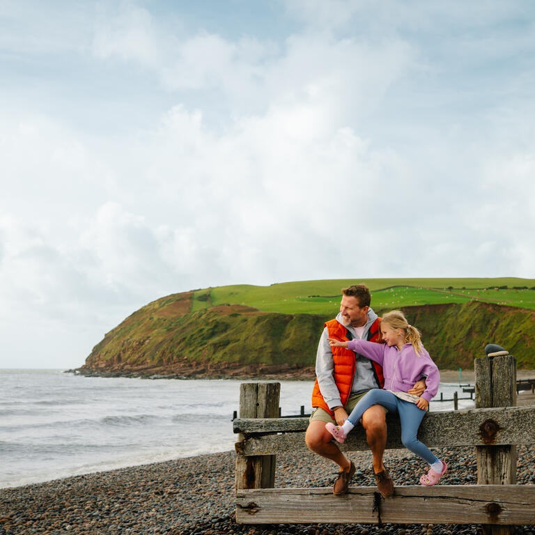 Father and daughter having fun on a beach
