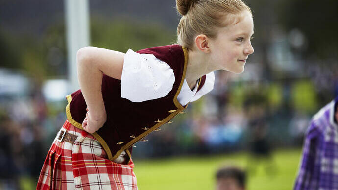 Child wearing a kilt leaning forward