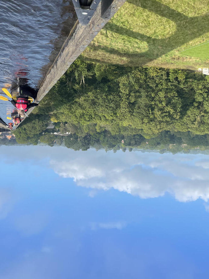 Un groupe pagayant en kayak sous un viaduc avec vue panoramique sur le parc national de Snowdonia/Eryri