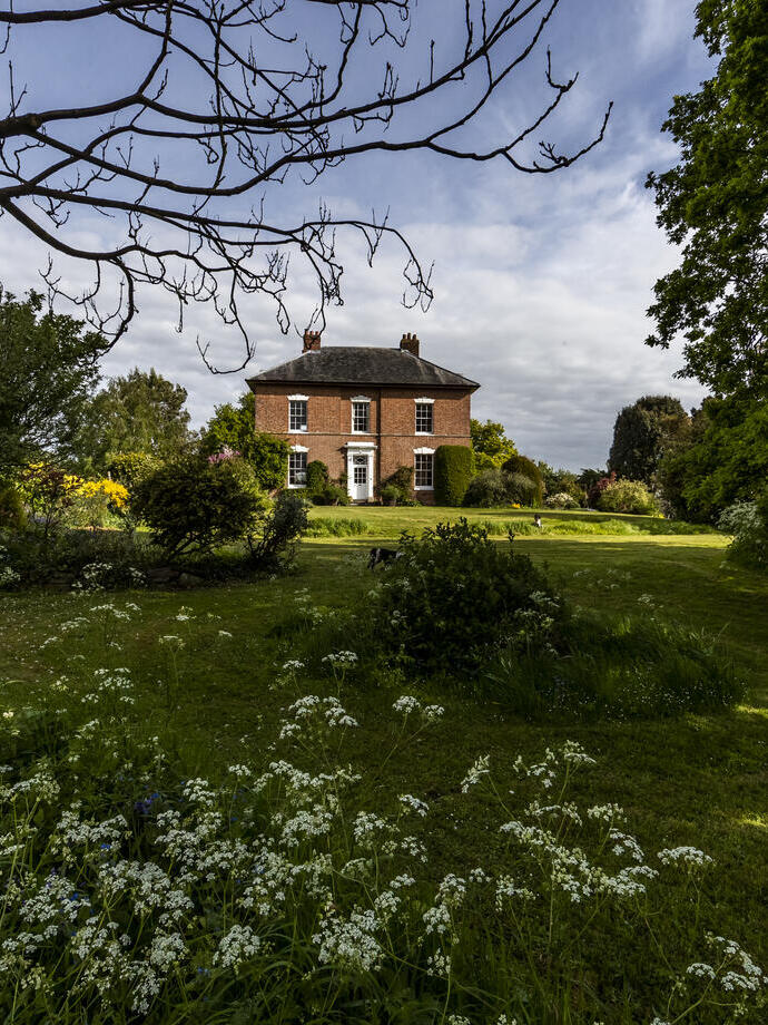 A stately period home surrounded by spring gardens.