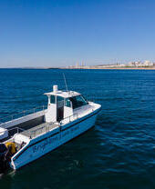 Un barco de pesca con señuelos frente a la costa de Brighton, decorado con el logotipo de Brighton Lure Boat