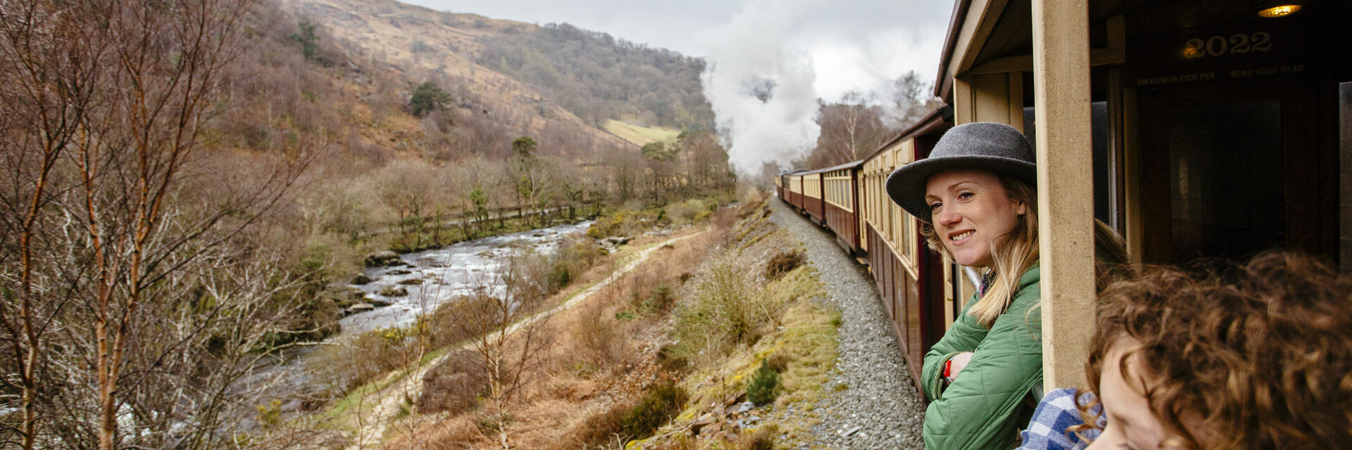 Frau und Kind, die sich aus dem Fenster eines Dampfzuges lehnen