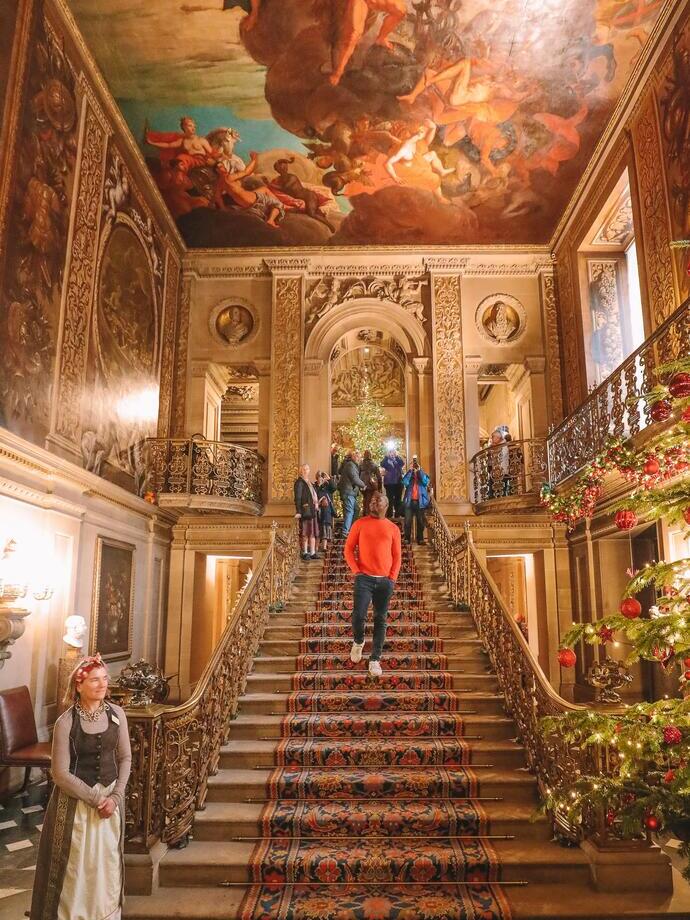 Group of people walking down stairs under a painted ceiling