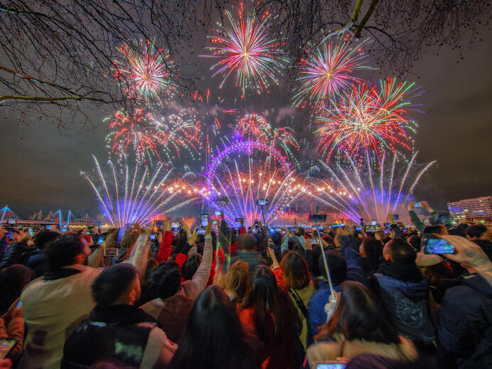 A crowd watching fireworks celebrating New Year's Eve