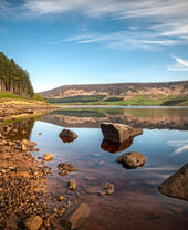 An outdoor shot of a reservoir with peaks in the background