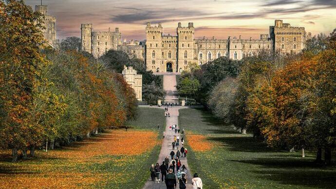 People walking down a tree lined road towards Windsor Castle
