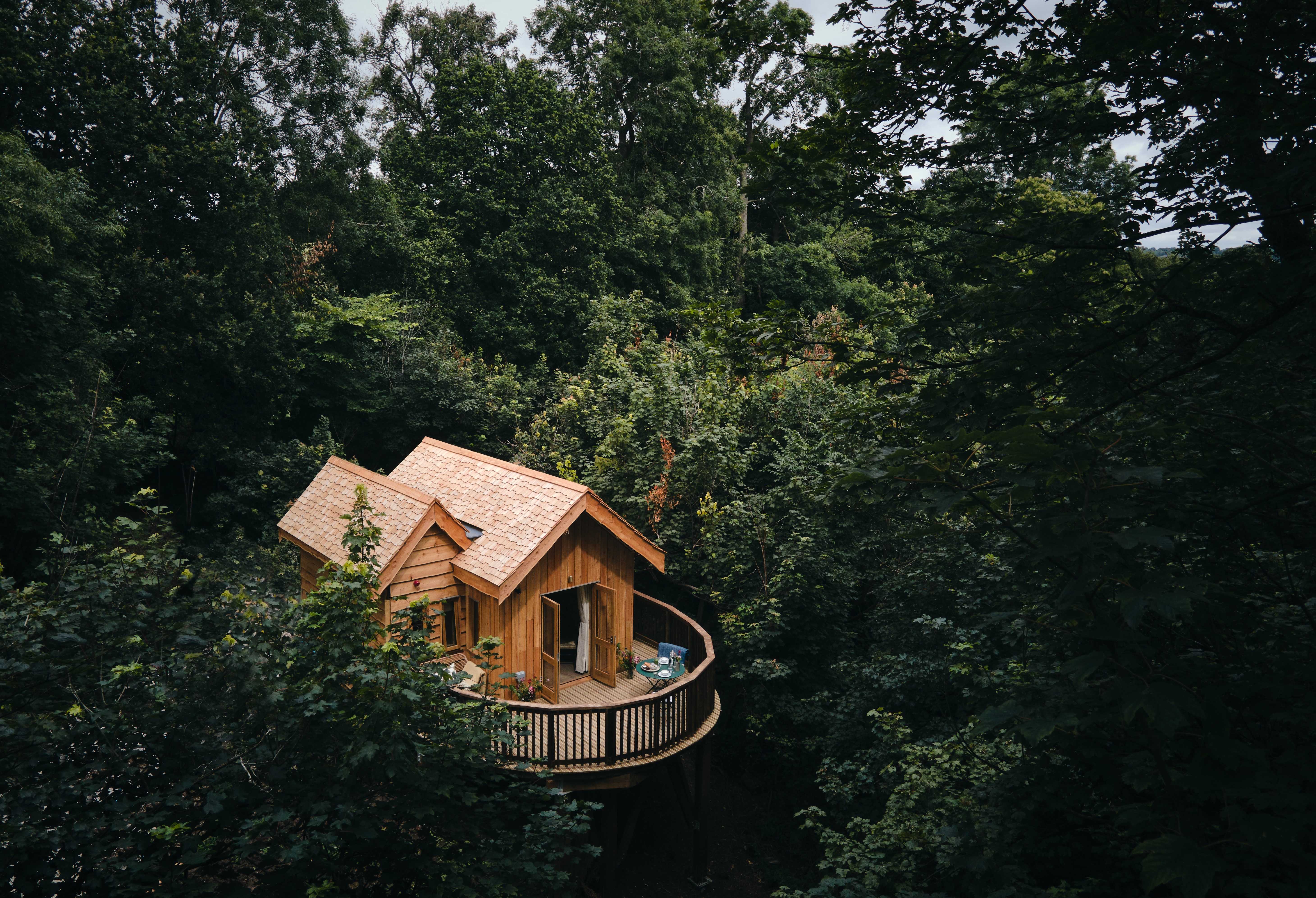 Aerial view of a wooden treehouse accommodation, nestled in a tree canopy