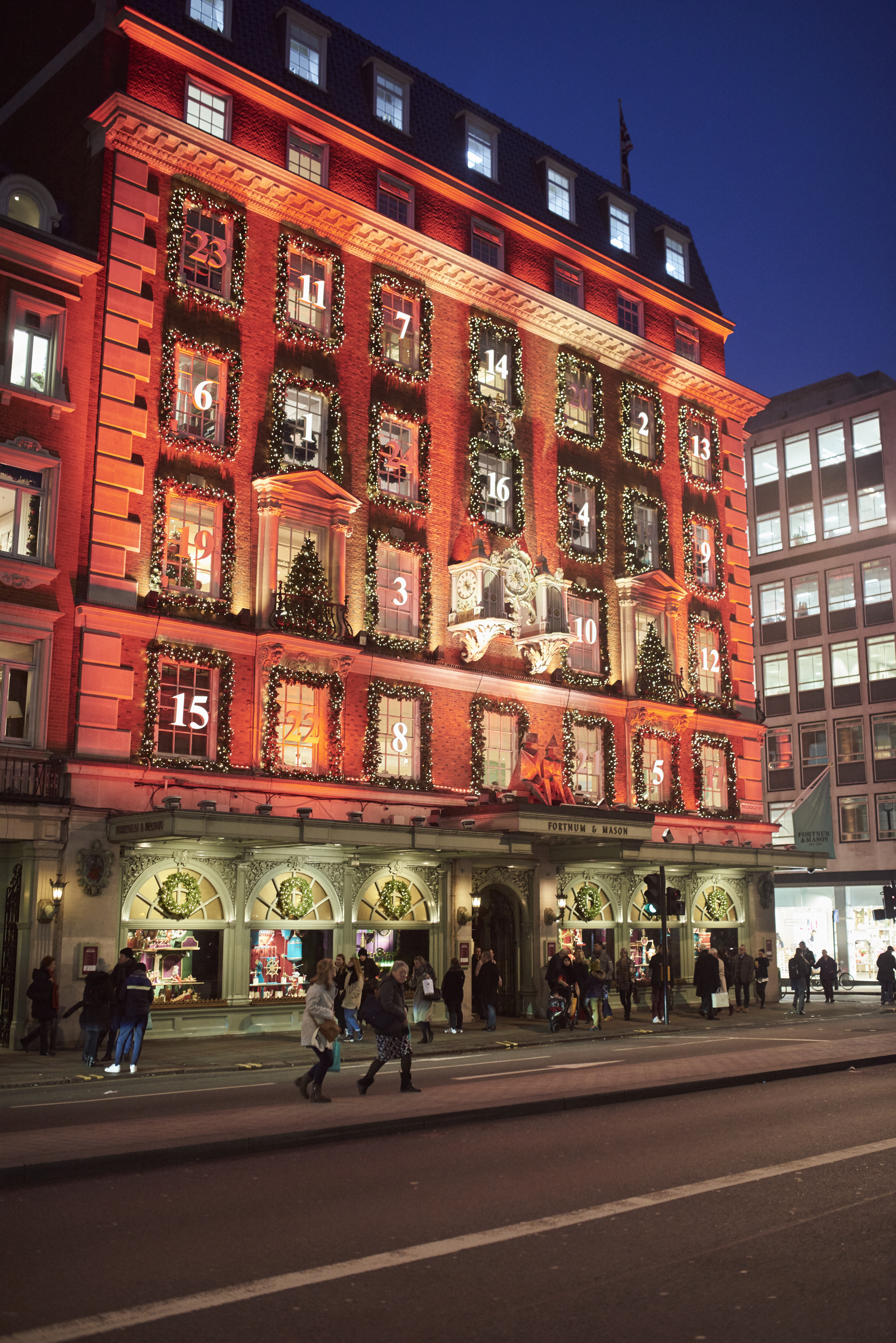 Eine Menschenmenge auf der Straße vor einem Kaufhaus bei Nacht