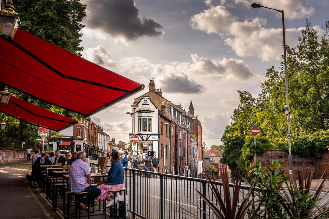 People sitting at tables outside on Norwich Lanes